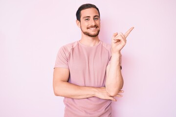 Young handsome man wearing casual tshirt smiling happy pointing with hand and finger to the side