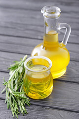 Bottle and jar of rosemary oil on table