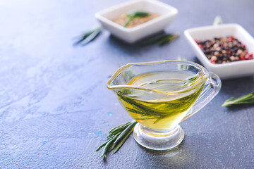 Gravy boat of rosemary oil on dark background
