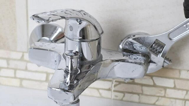 Fixing a water leaking tap Faucet by Plumber use Adjustable wrench , DIY job house bathroom shower keep work fix leak repair.
