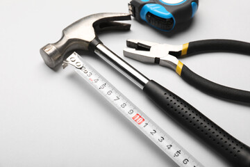 Measuring tape with builder's supplies on white background