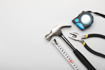 Measuring tape with builder's supplies on white background