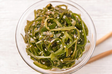 Bowl with tasty seaweed on table, closeup