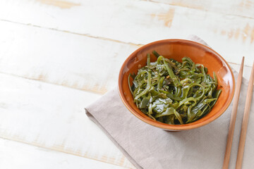 Bowl with tasty seaweed on table