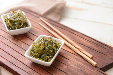 Bowls with tasty seaweed on table