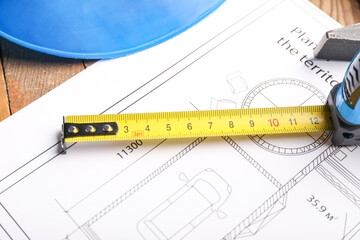 Measuring tape with blueprint on table