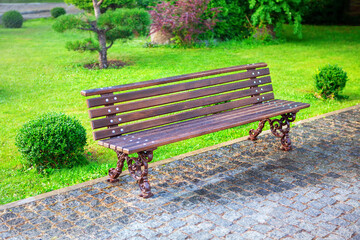 Park bench and green lawn . Nobody in the city park 