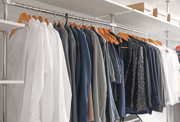 Hanger with stylish clothes in modern store