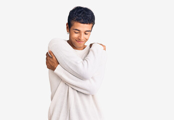 Young african amercian man wearing casual clothes hugging oneself happy and positive, smiling confident. self love and self care