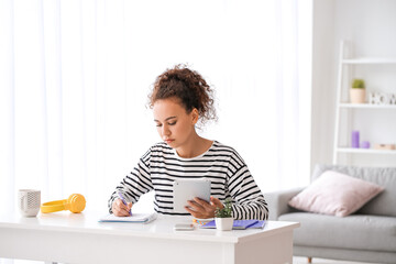 Young woman using tablet computer for online learning at home