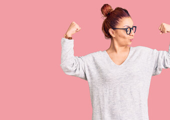 Young latin woman wearing casual clothes showing arms muscles smiling proud. fitness concept.