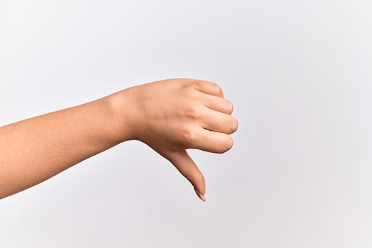 Hand of caucasian young woman doing thumbs down rejection gesture, disapproval dislike and negative sign