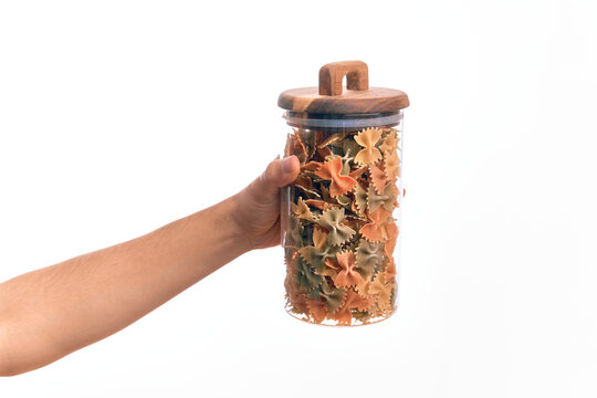 Glass jar full of dry italian vegetables pasta over isolated background