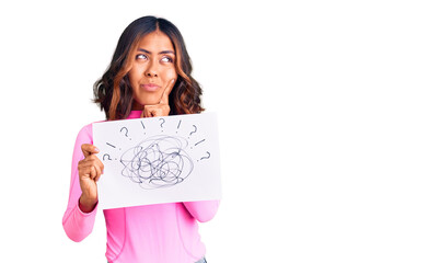 Young beautiful mixed race woman holding scribble draw serious face thinking about question with...