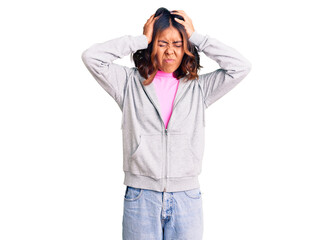 Young beautiful mixed race woman wearing casual sporty clothes suffering from headache desperate and stressed because pain and migraine. hands on head.