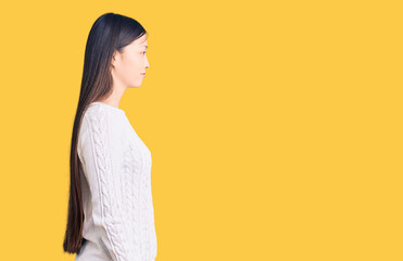 Obraz premium Young beautiful chinese woman wearing casual sweater looking to side, relax profile pose with natural face and confident smile.
