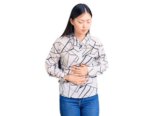 Young beautiful chinese woman wearing casual shirt with hand on stomach because indigestion, painful illness feeling unwell. ache concept.