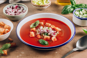Spanish summer cold soup gazpacho with vegetables on beige rustic background.