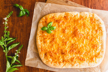 Homemade flat bread with cheeseand basil closeup on wooden background