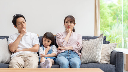 ソファーで考え事をする親子