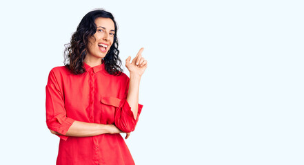 Young beautiful hispanic woman wearing casual clothes with a big smile on face, pointing with hand and finger to the side looking at the camera.