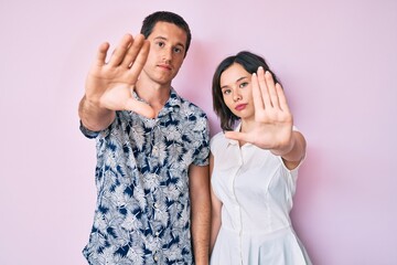 Beautiful couple wearing casual clothes doing frame using hands palms and fingers, camera perspective