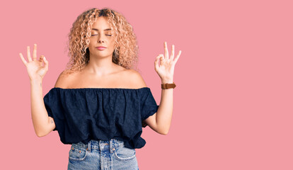 Young blonde woman with curly hair wearing casual summer clothes relax and smiling with eyes closed doing meditation gesture with fingers. yoga concept.