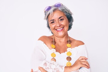 Senior hispanic grey- haired woman wearing casual hippie clothes happy face smiling with crossed arms looking at the camera. positive person.