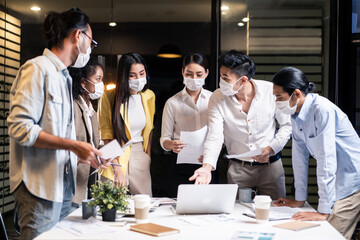 Late working of Asian business people with mask meeting in office