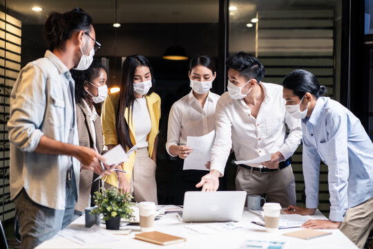 Late working of Asian business people with mask meeting in office
