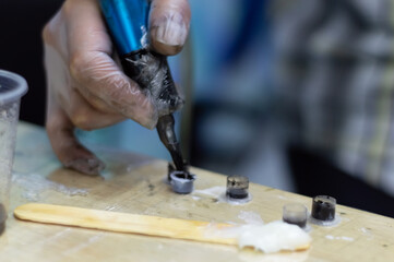 Tattoo artist holding a tattoo machine and dip into inks for tattooing