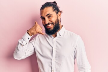 Young arab man wearing casual clothes smiling doing phone gesture with hand and fingers like talking on the telephone. communicating concepts.