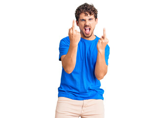 Young handsome man with curly hair wearing casual clothes showing middle finger doing fuck you bad...