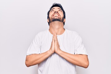Fototapeta premium Young hispanic man wearing casual clothes begging and praying with hands together with hope expression on face very emotional and worried. begging.