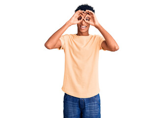 Young african american man wearing casual clothes doing ok gesture like binoculars sticking tongue out, eyes looking through fingers. crazy expression.