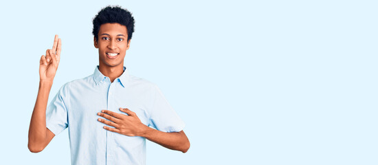 Young african american man wearing casual clothes smiling swearing with hand on chest and fingers...