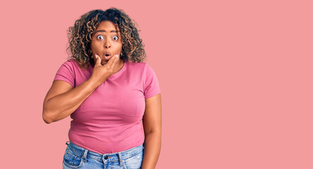 Young african american plus size woman wearing casual clothes looking fascinated with disbelief,...