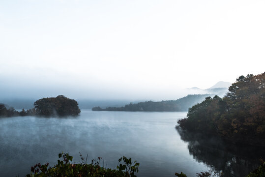 Beautiful autumn scenery, water mist over the lake and sea clouds on the mountain at dawm.