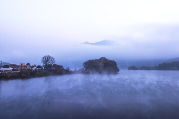Beautiful autumn scenery, water mist over the lake and sea clouds on the mountain at dawn.