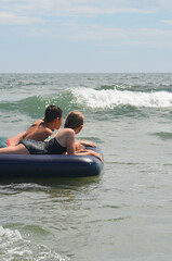 Caucasian children outdoor in summer swimming with inflatable mattress