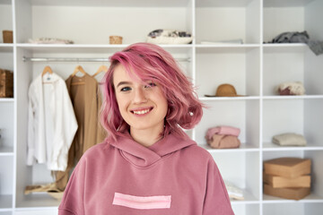Smiling hipster gen z teen girl fashion designer, blogger with pink hair piercing wearing hoodie...