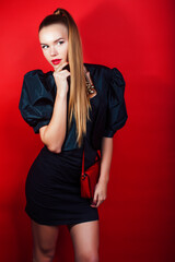 Fototapeta premium young pretty woman young lady posing on red background wearing gold jewelry, lifestyle people concept