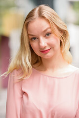 Fototapeta premium Face of young beautiful blonde woman in the city with nature