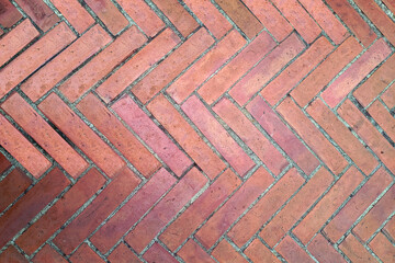 Vintage red brick floor in herringbone or zigzag pattern