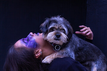 Teenage girl with Halloween makeup hugging her dog