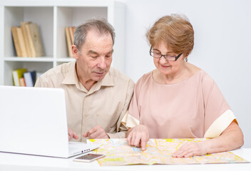 Senior couple look at map and plan holiday