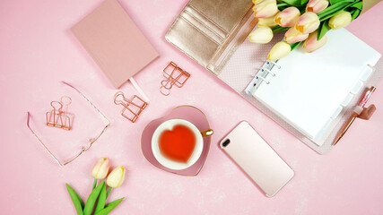 Feminine pink theme desktop workspace with personal planner on stylish textured background. Top view blog hero header creative composition flat lay.