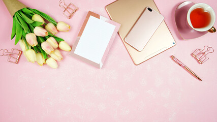 Feminine pink theme desktop workspace with rose gold tablet and phone devices on stylish textured background. Top view blog hero header creative composition flat lay.