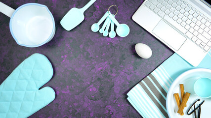Obraz na płótnie Canvas Cooking baking food theme desktop workspace with laptop on stylish purple textured background. Top view blog hero header creative composition flat lay. Stop motion animation.