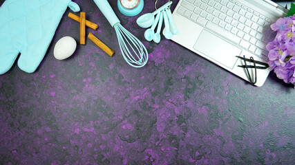 Cooking baking food theme desktop workspace with laptop on stylish purple textured background. Top view blog hero header creative composition flat lay. Stop motion animation.